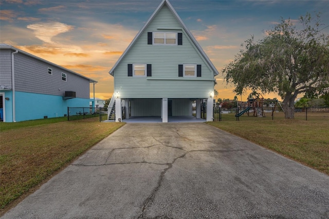 exterior space with a carport, a playground, and a lawn