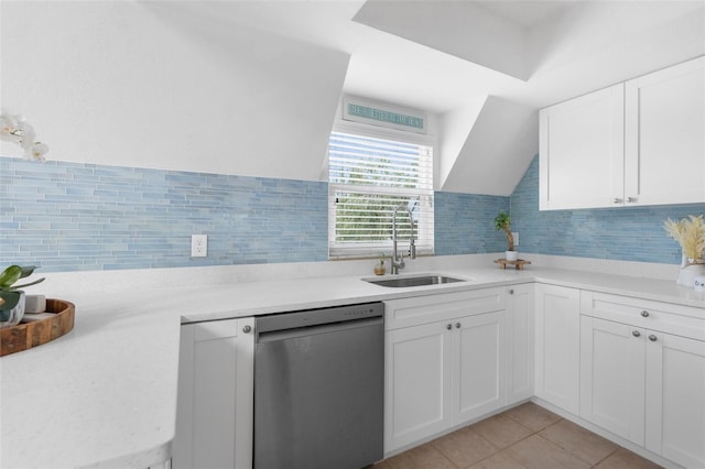 kitchen featuring white cabinets, dishwasher, light tile patterned flooring, and sink