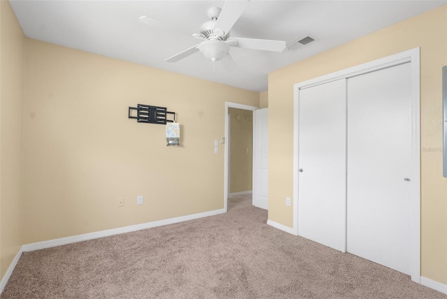 unfurnished bedroom featuring ceiling fan, a closet, and light colored carpet