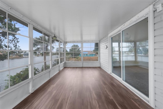 unfurnished sunroom featuring a water view and a healthy amount of sunlight