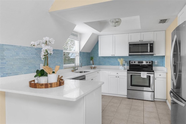 kitchen featuring visible vents, white cabinets, a sink, a peninsula, and stainless steel appliances