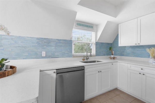 kitchen featuring light countertops, stainless steel dishwasher, a sink, and white cabinetry
