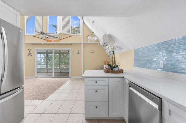 kitchen with a wall mounted AC, light carpet, light tile patterned floors, light countertops, and stainless steel appliances