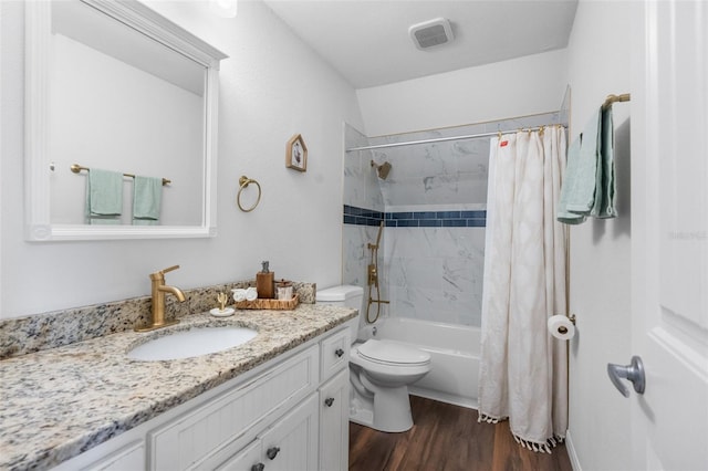 bathroom with vanity, shower / bath combo, toilet, visible vents, and wood finished floors