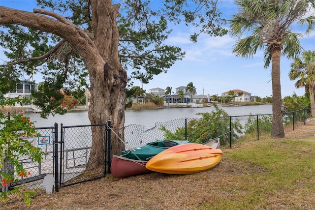 view of yard with fence, a water view, and a gate