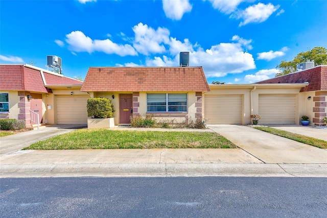 view of front of property featuring a garage and cooling unit