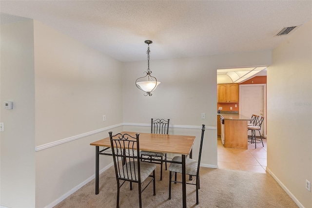 carpeted dining area featuring a textured ceiling