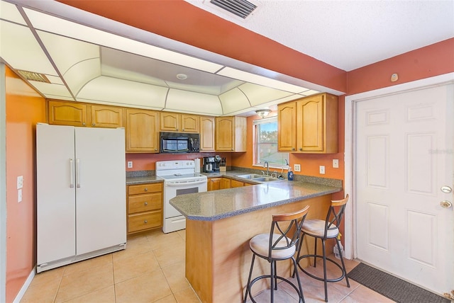 kitchen featuring kitchen peninsula, light tile patterned flooring, white appliances, and sink