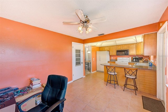 kitchen with sink, kitchen peninsula, white appliances, a breakfast bar, and light tile patterned floors