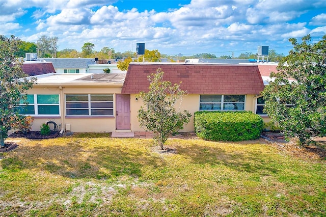 view of front of property with central AC and a front yard