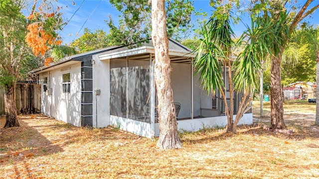 view of property exterior with a sunroom