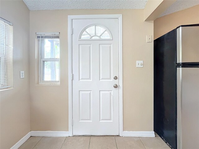 tiled entrance foyer featuring a textured ceiling