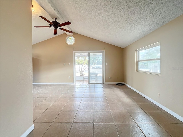 tiled empty room featuring vaulted ceiling with beams, ceiling fan, a healthy amount of sunlight, and a textured ceiling