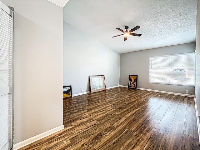 unfurnished living room featuring a textured ceiling, ceiling fan, and dark wood-type flooring