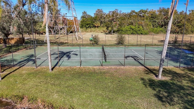 view of tennis court featuring a yard