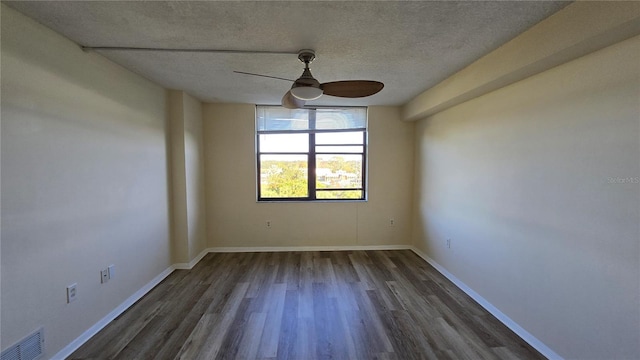 empty room featuring a textured ceiling, ceiling fan, and dark wood-type flooring