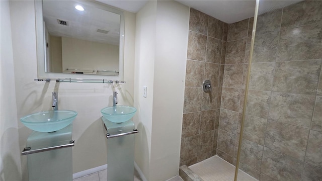 bathroom featuring a tile shower and sink