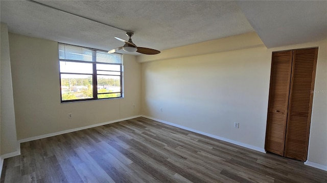 spare room with ceiling fan, dark hardwood / wood-style flooring, and a textured ceiling