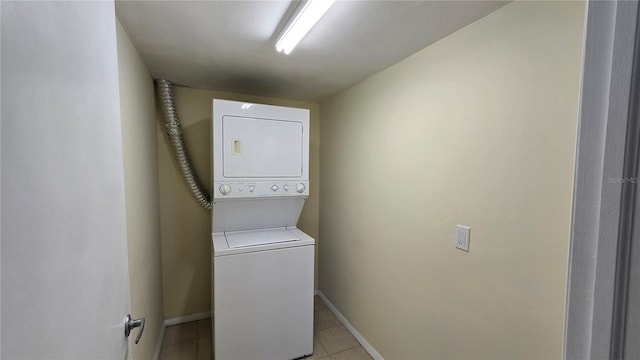 laundry room featuring light tile patterned floors and stacked washer / drying machine