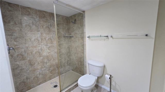 bathroom with a tile shower and toilet