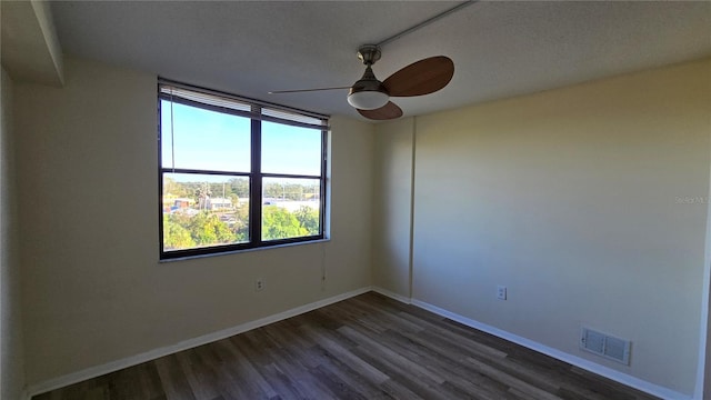 spare room featuring a textured ceiling, ceiling fan, and dark wood-type flooring