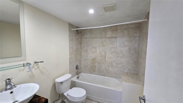 full bathroom featuring tile patterned flooring, tiled shower / bath combo, toilet, and sink