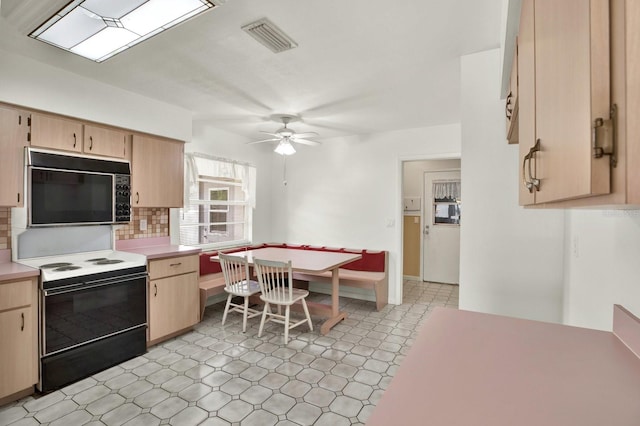 kitchen with decorative backsplash, light brown cabinetry, electric range, and ceiling fan