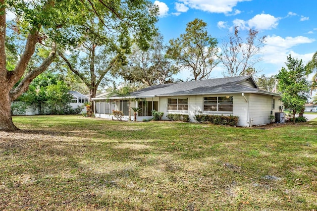 rear view of property with a lawn, a sunroom, and central air condition unit