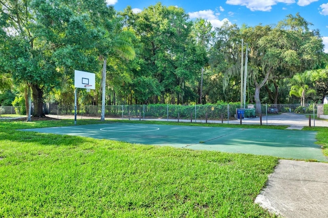 view of sport court featuring a lawn