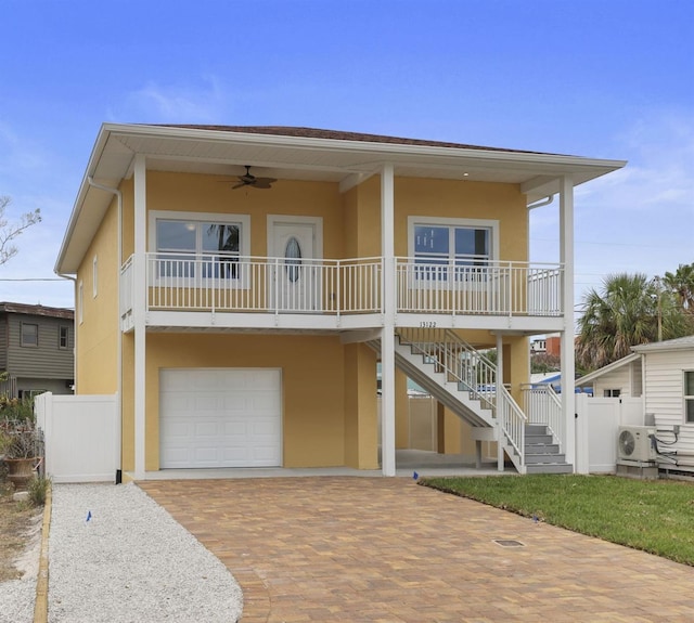 view of front of home featuring ceiling fan, ac unit, a porch, and a garage