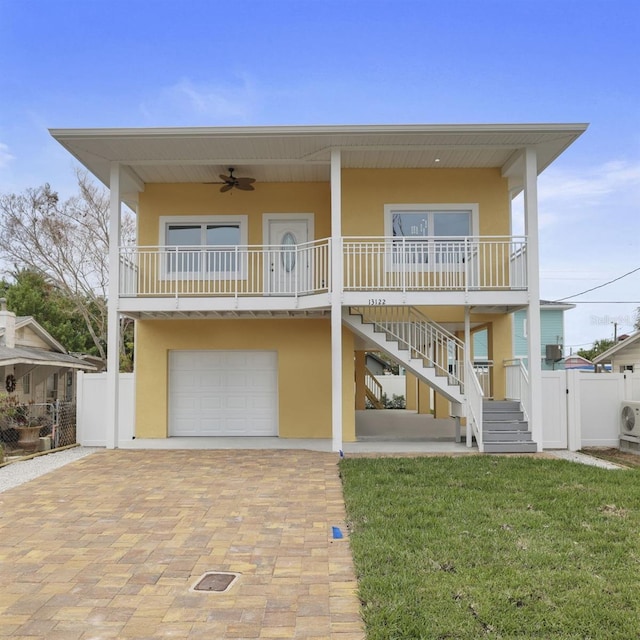 view of front facade featuring covered porch, a front lawn, a garage, and ceiling fan