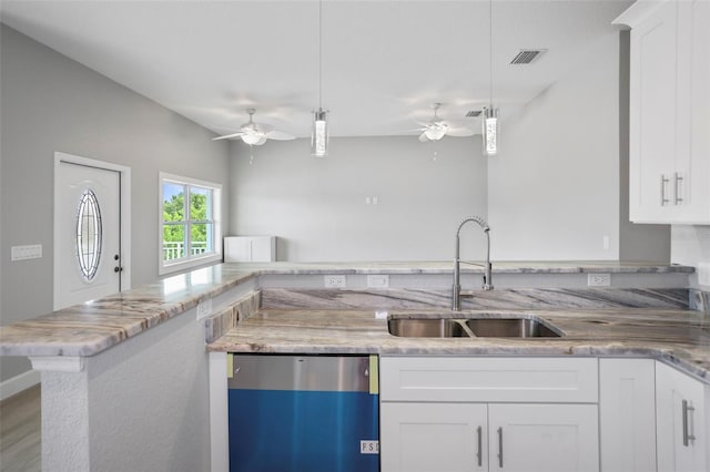 kitchen with decorative light fixtures, white cabinets, and sink