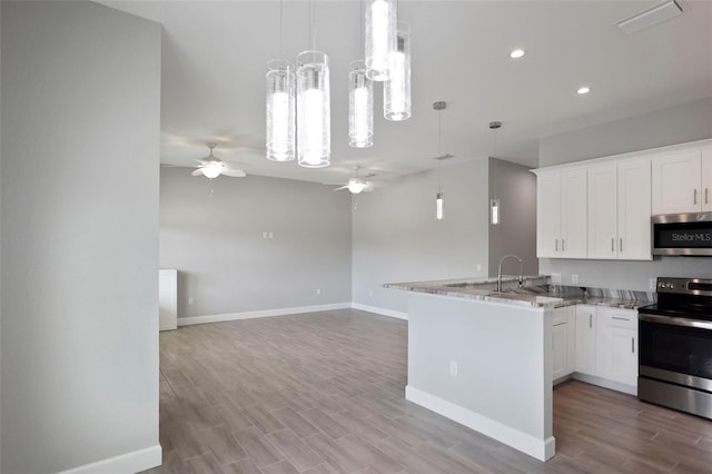 kitchen with ceiling fan, kitchen peninsula, stainless steel appliances, and white cabinetry