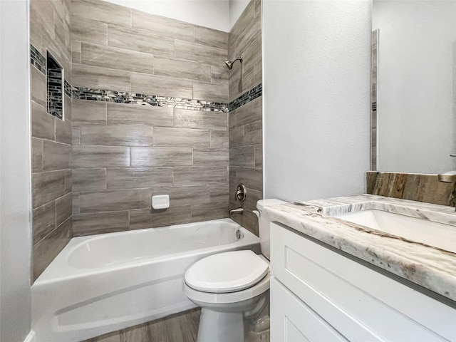 full bathroom featuring toilet, tiled shower / bath, vanity, and hardwood / wood-style flooring