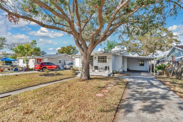 ranch-style home featuring a front lawn and a carport