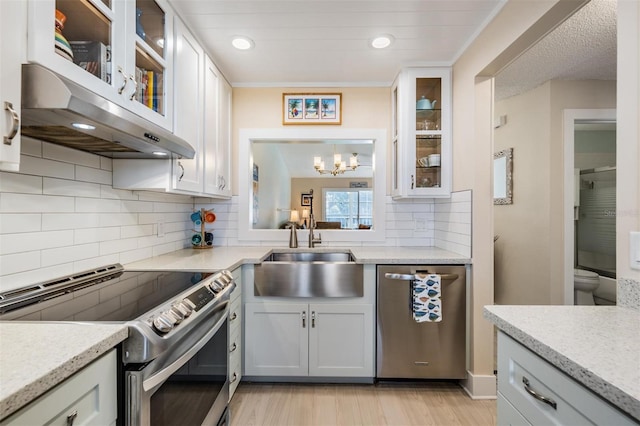 kitchen with sink, decorative backsplash, white cabinetry, and appliances with stainless steel finishes