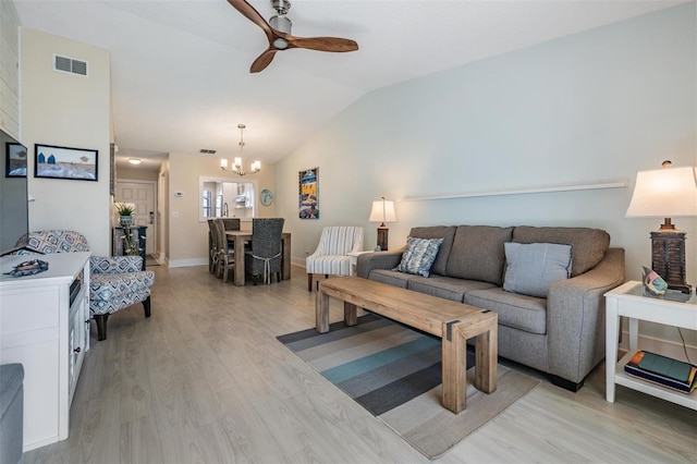 living room featuring ceiling fan with notable chandelier, light hardwood / wood-style flooring, and lofted ceiling