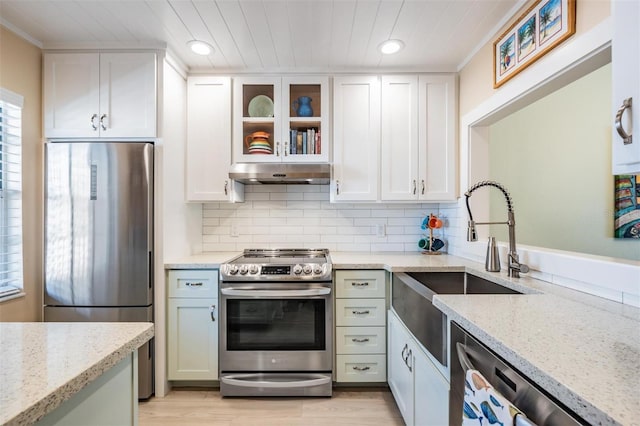 kitchen with tasteful backsplash, stainless steel appliances, white cabinetry, and light stone countertops