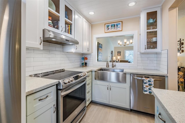 kitchen with sink, white cabinets, light stone counters, tasteful backsplash, and appliances with stainless steel finishes