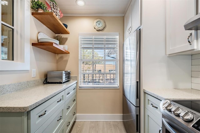 kitchen featuring light hardwood / wood-style flooring, refrigerator with ice dispenser, wall chimney range hood, electric range, and white cabinets