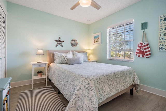 bedroom featuring a closet, ceiling fan, a textured ceiling, and dark hardwood / wood-style floors