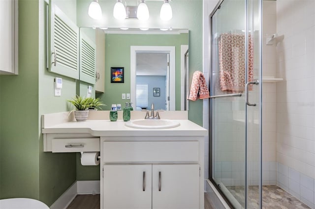 bathroom with a shower with door and vanity