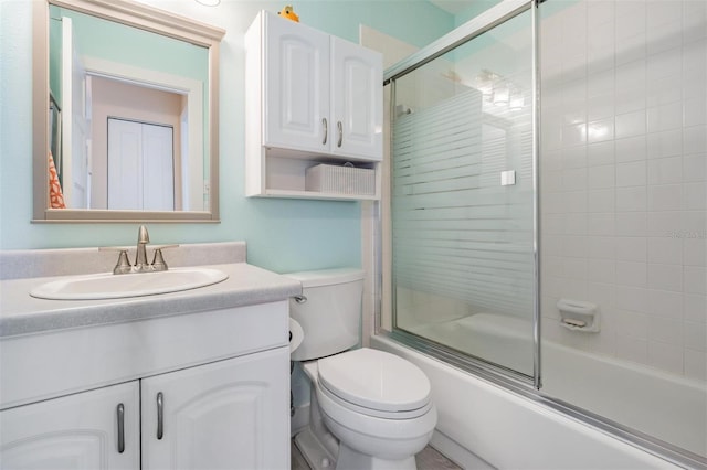 full bathroom featuring shower / bath combination with glass door, vanity, and toilet