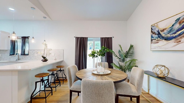 dining area featuring light wood-type flooring and sink