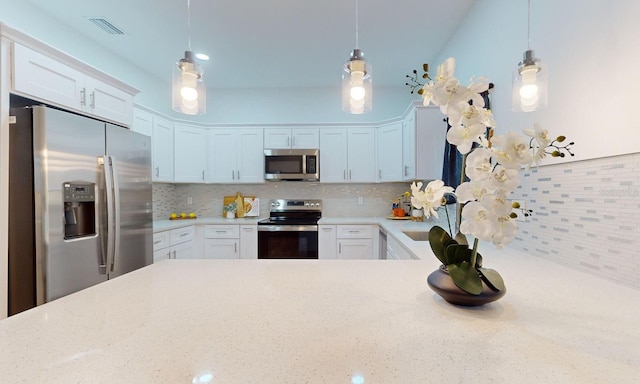 kitchen featuring decorative backsplash, pendant lighting, and stainless steel appliances