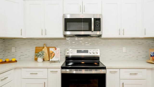 kitchen featuring white cabinets, appliances with stainless steel finishes, and backsplash