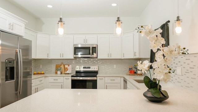 kitchen featuring pendant lighting, white cabinetry, appliances with stainless steel finishes, and tasteful backsplash