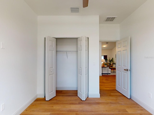 bedroom featuring light hardwood / wood-style flooring, a closet, and ceiling fan