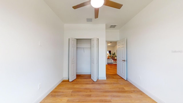 unfurnished bedroom with ceiling fan, a closet, and light hardwood / wood-style floors