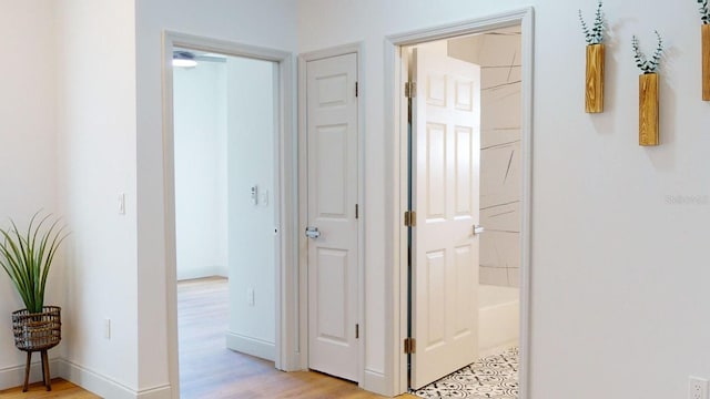 corridor with light hardwood / wood-style floors